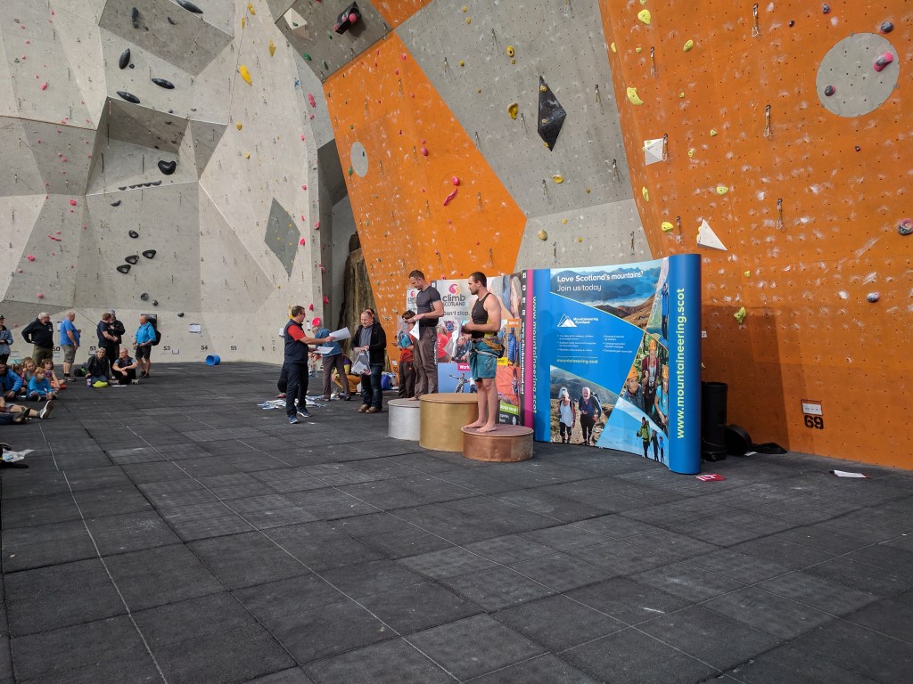 A picture of Jesse on the podium at Ratho, an indoor climbing wall in Edinburgh, Scotland. This was his first climbing competition