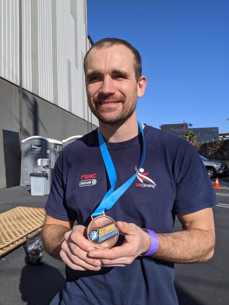 A photo of Jesse holding his bronze medal.